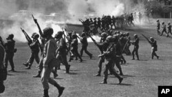 FILE - In a May 4, 1970 file photo, Ohio National Guard moves in on rioting students at Kent State University in Kent, Ohio. Four persons were killed and eleven wounded when National Guardsmen opened fire. The U.S. Justice Department, citing "insurmountable legal and evidentiary barriers," won't reopen its investigation into the deadly 1970 shootings by Ohio National Guardsmen during a Vietnam War protest at Kent State University. Assistant Attorney General Thomas Perez discussed the obstacles in a letter to Alan Canfora, a wounded student who requested that the investigation be reopened. The Justice Department said Tuesday, April 24, 2012 it would not comment beyond the letter. (AP Photo, File)