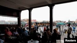 Tourists sit in a cafe at Jamaa Lafna square in Marrakech, Morocco, March 15, 2020. 