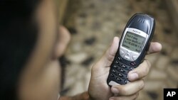 A Pakistani man with his mobile phone containing a prank message, Karachi, April 2007 (file photo).