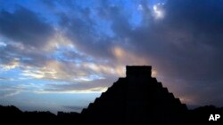 FILE - The sun rises behind Kukulkan temple in the Mayan ruins of Chichen Itza, Mexico, Dec. 2012. 