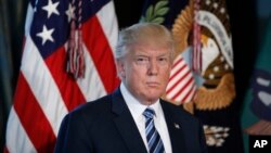 President Donald Trump listens as Treasury Secretary Steve Mnuchin speaks at the Treasury Department in Washington, April 21, 2017. 