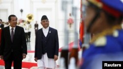 នាយក​រដ្ឋ​មន្ត្រី​ប្រទេស​នេប៉ាល់ លោក​ខាត់ហ្គា ប្រាសាត​ សាម៉ា អូលី (Khadga Prasad Sharma Oli) ដើរអមលោកនាយករដ្ឋមន្ត្រី ហ៊ុន សែន កាន់ក្បួនព្យុហយាត្រា នៅក្នុងជំនួបពិភាក្សាគ្នាមួយ នៅវិមានសន្តិភាព រាជធានីភ្នំពេញ ថ្ងៃទី១៣ ខែឧសភា ឆ្នាំ២០១៩។ (REUTERS/Samrang Pring)