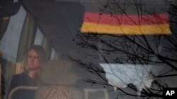 Turis Jerman yang terlantar duduk di sebuah bis yang membawanya ke bandara internasional di Kathmandu, Nepal, 27 Maret 2020. 