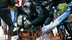 Riot police detain a demonstrator with a bloody face during a protest against the jailing of opposition leader Alexei Navalny in Pushkin square in Moscow, Russia, Jan. 23, 2021.