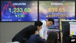 Wafanyabiashara wa sarafu wakifuatilia bei za fedha za kigeni katika benki ya KEB Hana, Seoul, Korea Kusini, Jumatatu, Aprili 27, 2020. Masoko ya hisa ya Asia yalipanda baada ya benki kuu ya Japan kuahidi kununua bondi.