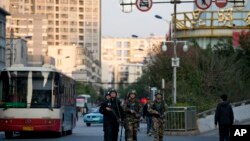Polisi dan paramiliter bersenjata berpatroli dekat stasiun kereta api Kunming, tempat serangan penusukan yang menewaskan lebih dari 30 orang. (AP/Alexander F. Yuan)