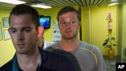 American Olympic swimmers Gunnar Bentz, left, and Jack Conger, center, leave the police station at Rio International airport early Thursday Aug. 18, 2016. 