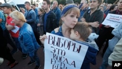 A woman holds a poster that reads: "Elections are when you can choose," as people gathered for a protest in St. Petersburg, Russia, Sept. 5, 2019. 
