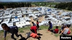FILE - Syrian refugee children play together, as Lebanon extends a lockdown to combat the spread of the coronavirus disease (COVID-19) at a Syrian refugee camp in the Bekaa valley, Lebanon May 7, 2020. 
