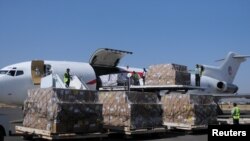 Para pekerja mengeluarkan bantuan pangan dari pesawat pengangkut di bandara Sana'a, Yaman, 25 November 2017. 