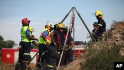 Petugas penyelamat darurat berusaha untuk membebaskan penambang liar yang terjebak di bekas poros tambang emas dekat Benoni, Afrika Selatan, Minggu (16/2).