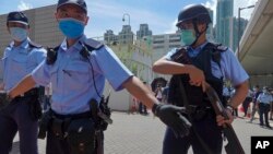 មន្ត្រី​ប៉ូលិស​ឈរ​យាម​បុរស​អាយុ ២៣ឆ្នាំ​ឈ្មោះ Tong Ying-kit​ ពេល​មក​ដល់​តុលាការ​នៅ​ទីក្រុង​ហុងកុង កាល​ពី​ថ្ងៃ​ទី​៦ កក្កដា ២០២០។ លោក Tong Ying-kit គឺ​ជា​មនុស្ស​ទី១ ដែល​ត្រូវ​បា​នចោទ​ប្រកាន់​ដោយ​ច្បាប់​សន្តិសុខ​ថ្មី​ដោយ​រង​ការ​ចោទ​ប្រកាន់​ថា​បើក​ម៉ូតូ​ចូល​ក្នុង​ក្រុម​ប៉ូលិស។