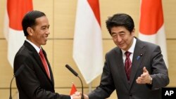 Presiden Joko Widodo bersama Perdana Menteri Jepang Shinzo Abe dalam konferensi pers gabungan di kediaman Abe di Tokyo, Maret 2015. (AP/Franck Robichon)