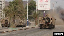 Kendaraan militer lewat saat bentrokan dengan milisi Houthi di kota Aden, 17 Juli 2015.