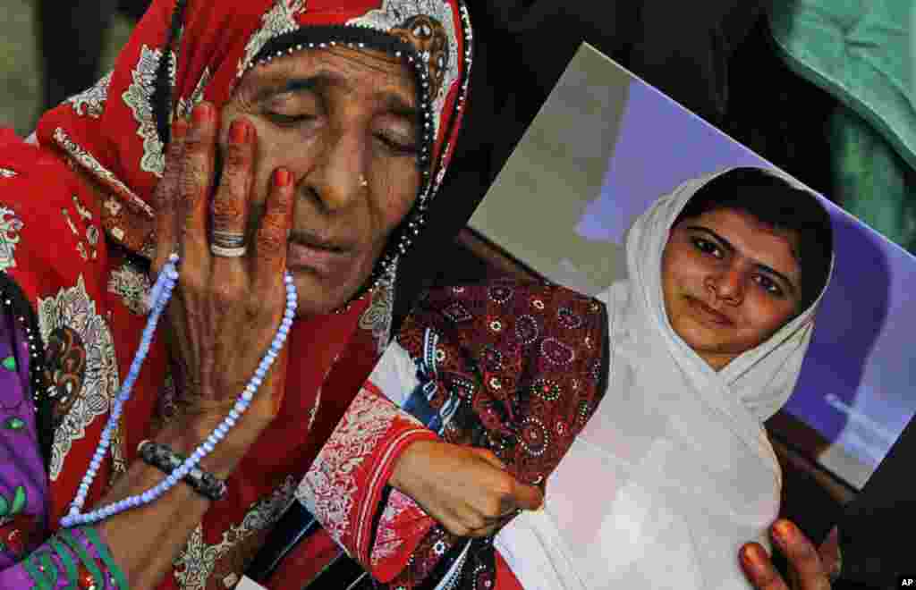 A supporter of Pakistani political party Muttahida Qaumi Movement (MQM), reacts while holding a poster of&nbsp; Malala Yousufzai during a rally to condemn the attack in Karachi, Pakistan, October 14, 2012.