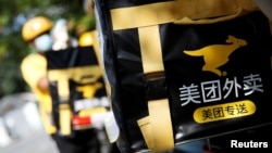 北京金融区的一个美团外送小哥骑着电摩在外送。（2020年7月15日）