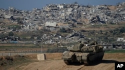 Israeli soldiers take up positions near the Gaza Strip border, in southern Israel, Sunday, Jan.7, 2024.