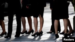 Female office workers wearing high heels, clothes and bags of the same colour are seen at a business district in Tokyo, Japan, June 4, 2019. REUTERS/Kim Kyung-Hoon