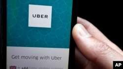 FILE - An Uber app is displayed on a phone in London, Sept. 22, 2017.