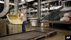 FILE - A UPS employee works inside the company's Worldport hub in Louisville, Ky. 
