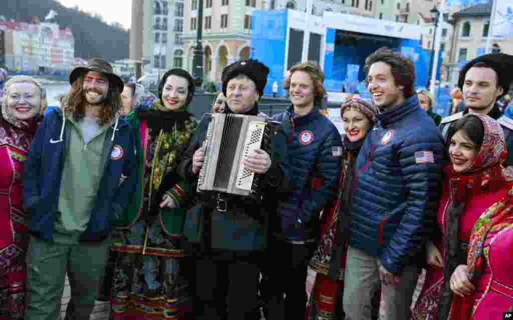 Para anggota tim ski gaya bebas AS dengan kelompok paduan suara dan tari Cossack dalam kostum tradisional di Rosa Khutor (6/2).