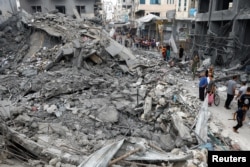 Warga Palestina memeriksa kerusakan pasca serangan Israel, di Khan Younis, Jalur Gaza selatan, 10 Oktober 2023. (Foto: REUTERS/Ibraheem Abu Mustafa)