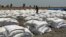 Bags of food dropped by air from a World Food Program plane are sorted in Padeah, South Sudan. South Sudanese who fled famine and fighting in Leer county emerged from South Sudan's swamps after months in hiding to receive food aid.
