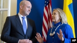 Swedish Prime Minister Fredrik Reinfeldt, left, greets US Secretary of State Hillary Rodham Clintonas she arrives for meetings at Rosenbad in Stockholm, Sweden, Sunday, June 3, 2012.