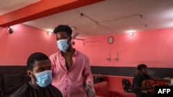 Kofi, a barber, resumes work after the partial lockdown halt the spread of the COVID-19 was lifted in Accra, Ghana, April 20, 2020.