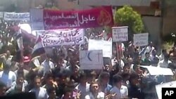 An image grab taken from YouTube shows Syrian anti-regime protesters marching during a rally in the northeastern city of Kafr Nabl, June 3, 2011