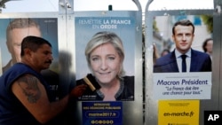 Poster kampanye capres Perancis di Antibes, Perancis, 14 April 2017. Dari kanan: pemimpin gerakan politik En Marche! (Onwards!) Emmanuel Macron dan pemimpin partai Fron Nasional Perancis (FN), Marine Le Pen. (REUTERS/Eric Gaillard).