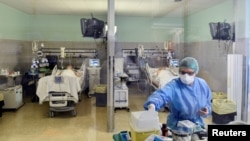 បុគ្គលិក​ពេទ្យ​ពាក់​ម៉ាស​និង​សម្លៀក​បំពាក់​ការពារ កំពុង​ព្យាបាល​អ្នក​ជំងឺ​កូវីដ១៩ នៅ​មន្ទីរ​ពេទ្យ Oglio Po ក្រុង Cremona ប្រទេស​អ៊ីតាលី កាល​ពីថ្ងៃ​ទី​១៩ មីនា ២០២០។