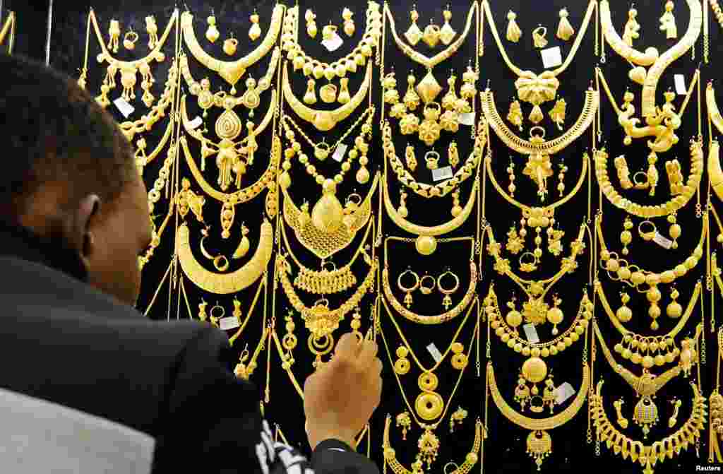 បុរស​ម្នាក់តម្រៀប​គ្រឿងអលង្ការ​មាស​នៅ​ខាងក្រុង​ហាង​មួយ​ក្នុង​ផ្សារ Wuse ទីក្រុង Abuja ប្រទេស​នីហ្ស៊េរីយ៉ា។