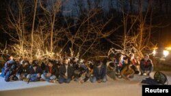 FILE - Greek Army soldiers detain a group of migrants that crossed from Turkey to Greece, near the village of Protoklisi, in the region of Evros, Greece, March 10, 2020. 