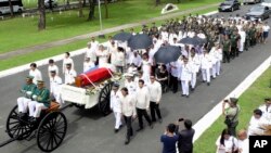 Dalam foto yang dibagikan oleh dari Kantor Gubernur Ilocos Norte, Imee Marcos, Imelda Marcos berbusana hitam di kursi roda di bawah payung, janda dari Almarhum Ferdinand Marcos, dan keluarga dekat mereka mengikuti peti mati yang diselimuti bendera dalam sebuah acara pemakaman (18/11) di Taman Makam Pahlawan Taguig City, Filipina.