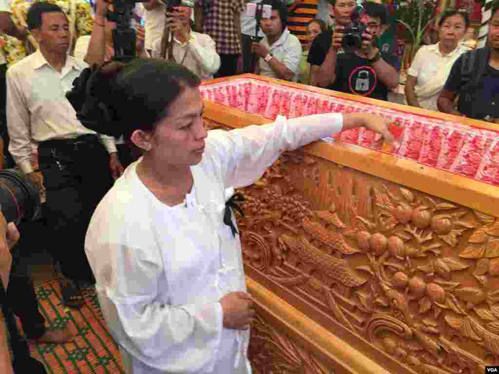 បងប្អូន សាច់ញ្ញាតិ និង​អ្នកចូលរួម​ក្នុង​ពិធីបុណ្យ​សព រៀប​បញ្ចុះ​សព​លោក​កែម ឡី ​នៅ​ស្រុក​កំណើត​របស់​លោក​ក្នុង​ឃុំ​លាយបូ ស្រុក​ត្រាំកក់ ខេត្ត​តាកែវ នា​ថ្ងៃ​ច័ន្ទ ទី២៥ ខែ​កក្កដា ឆ្នាំ​២០១៦។ (ហ៊ុល រស្មី/VOA)