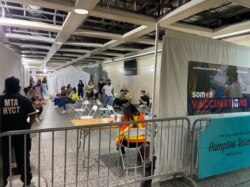 FILE - People wait to get a free COVID-19 vaccine at Penn Station, in New York City, June 8, 2021.