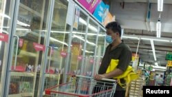 Seorang pria melihat produk makanan beku di supermarket di tengah wabah Covid-19 di Beijing, China, 13 Agustus 2020. (Foto: Reuters)
