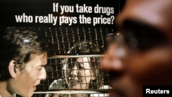 FILE - Human rights lawyer M. Ravi stands in front of a drug prevention advertisement outside the Singapore Changi Prison, Jan. 25, 2007. 