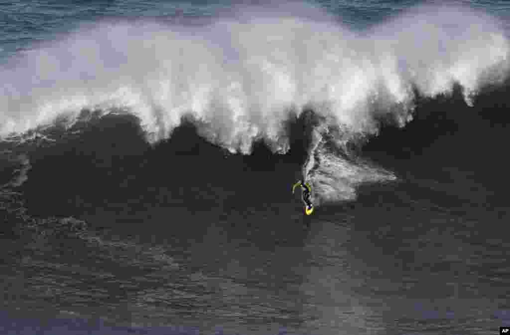 Peselancar AS Garrett McNamara menari di atas ombak di pantai Praia do Norte di Nazare, Portugis (29/1).