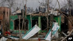 Kashmiri villagers watch the damage to residential houses at the site of a gun-battle in Mujagund area some 25 Kilometers (16 miles) from Srinagar, Indian controlled Kashmir, Dec. 9, 2018.