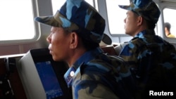 FILE - Crewmen aboard a Vietnam coastguard ship look at a Chinese navy frigate on a screen, in disputed waters close to the Haiyang Shiyou 981, known in Vietnam as HD-981, oil rig in the South China Sea, July 15, 2014.