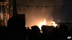 Small restaurants burn after a car bomb attack in the Shiite district of Baghdad's Sadr City, Dec. 4, 2014. 