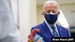 President Joe Biden looks at a model of Covid-19 as he visits the Viral Pathogenesis Laboratory.