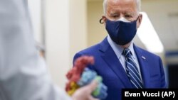 President Joe Biden looks at a model of Covid-19 as he visits the Viral Pathogenesis Laboratory at the National Institutes of Health in Bethesda, Md. 
