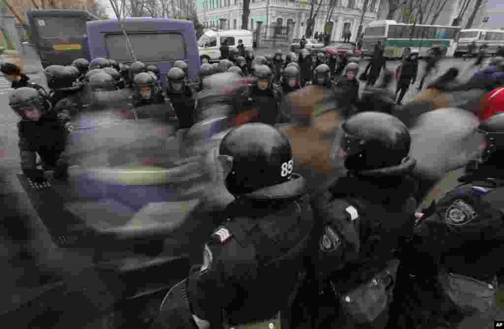 Para aktivis pro-Uni Eropa berjalan melewati garis polisi saat berbaris melawan pemerintah di Kiev, 17 Desember 2013.