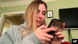 In this Nov. 1, 2018 photo, Laurel Foster holds her phone in San Francisco. Foster is among teens involved in Stanford University research testing whether smartphones can be used to help detect depression and potential self-harm. (AP Photo/Haven Daley)