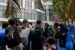 Journalists take pictures and video over the water-filled barriers after an opening ceremony for the China's new Office for Safeguarding National Security in Hong Kong, July 8, 2020.