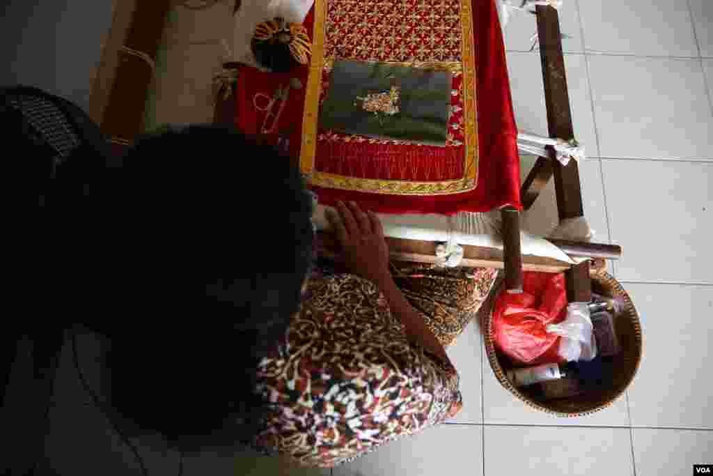 លោកស្រី មឿន ថារី អង្គុយចាក់ឌិននៅក្នុងផ្ទះរបស់លោកស្រីនៅជាន់ទីបួននៃអគារប៊ុលឌីញ។ រូបរបស់លោកស្រី ថារី ត្រូវបានវិចិត្រករជាតិអាមេរិចកាំងម្នាក់គូរលើជញ្ជាំងប៊ុលឌិញ មុននឹងត្រូវបានអាជ្ញាធរលុបចោលវិញកាលពីសប្ដាហ៍មុន។ (អូនឆេងប៉រ/VOA)&nbsp;