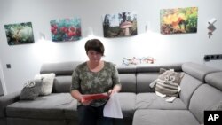 Elena Koposova čita u svojoj kući u selu Rogača, Srbija, utorak, 13. februara 2024. (AP Photo/Darko Vojinovic)